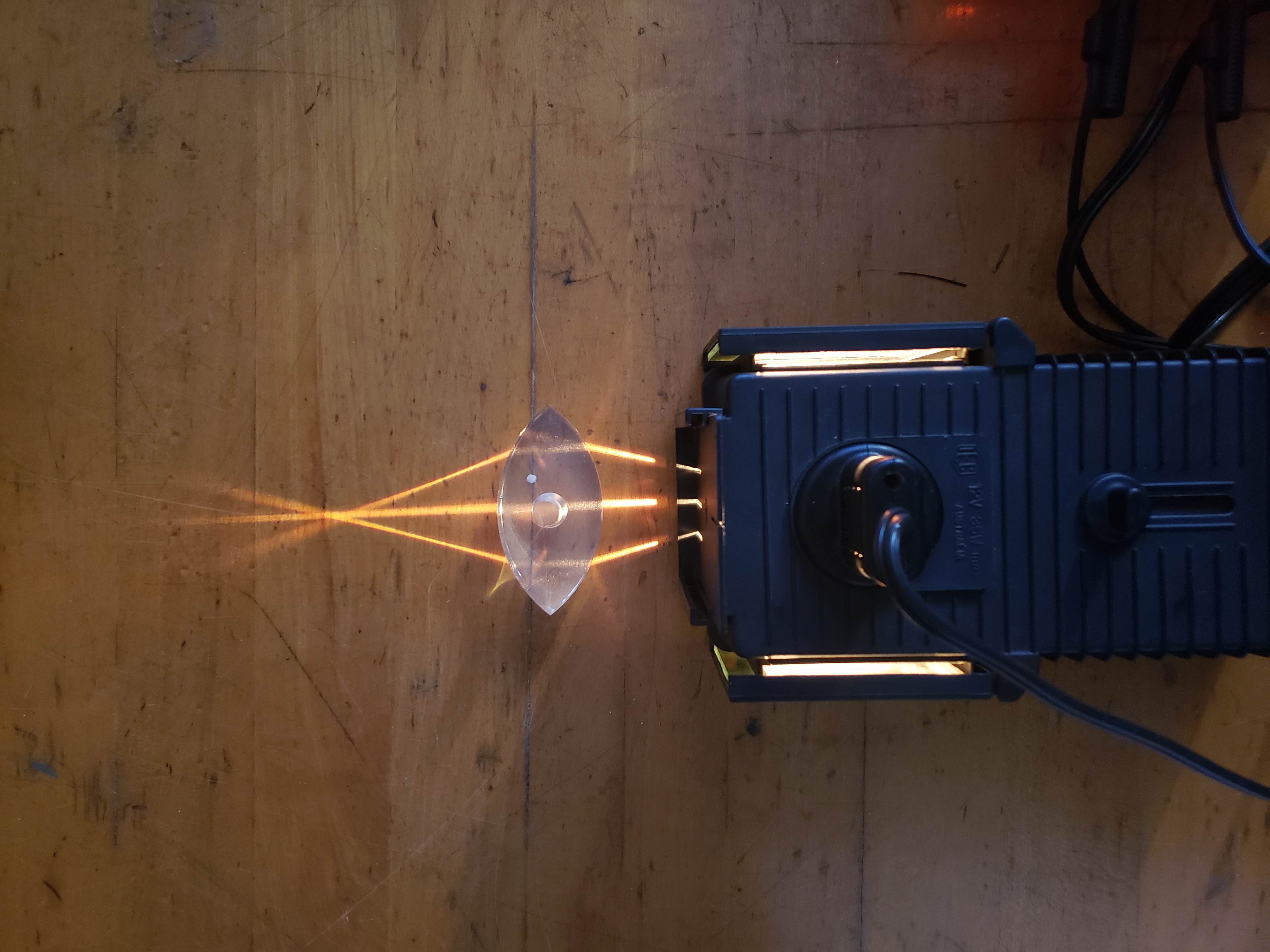 three rays of light converging after passing through a convex lens