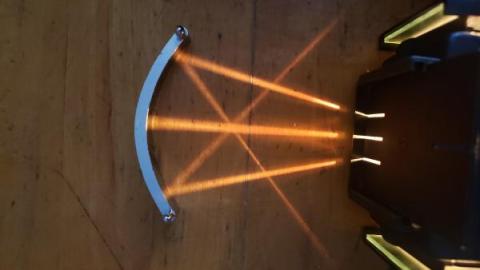 three rays of light converging as they are reflected by a curved mirror